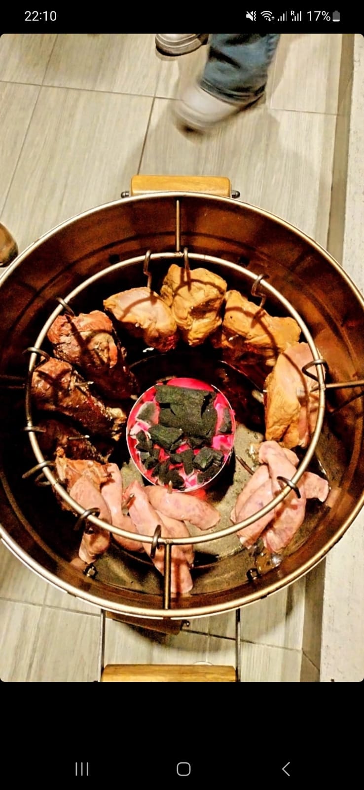 Vista cenital del interior del barril con carnes y brasas encendidas